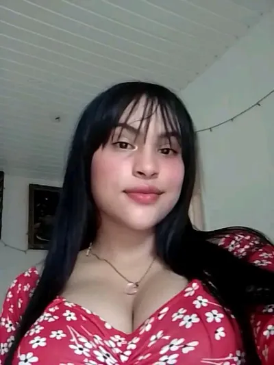 A woman in a red floral dress taking a selfie
