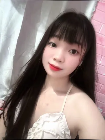 A young woman with long dark hair smiling indoors