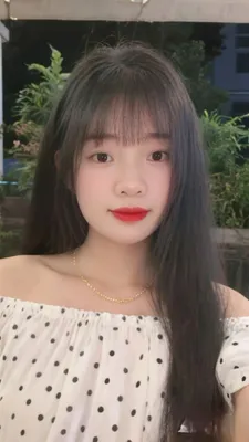 A young woman with long dark hair on a casual video call outdoors