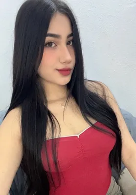 A woman with long black hair in a red top taking a selfie